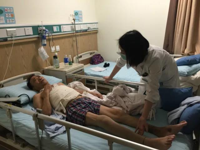 康復(fù)師為患者進(jìn)行肢體活動(dòng)，直腿抬高